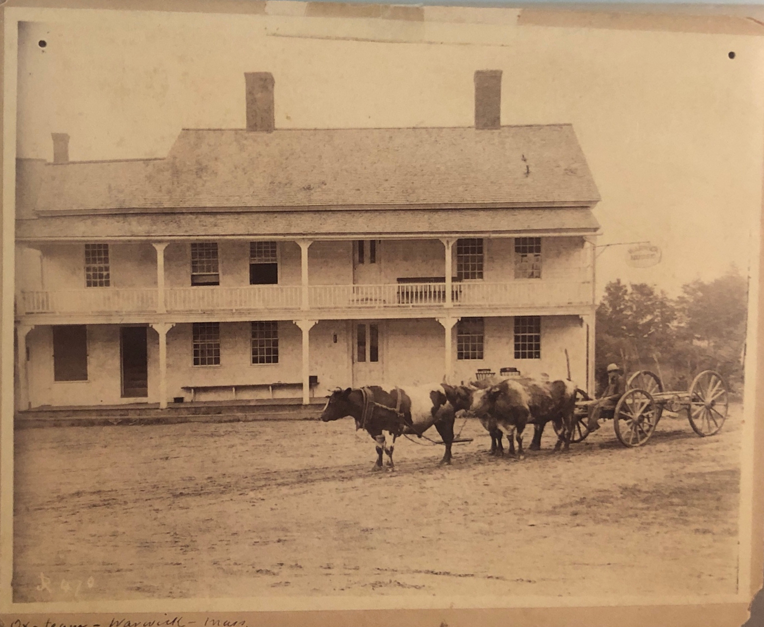 Image of a wagon pulled by oxen in front of Warwick Inn, undated