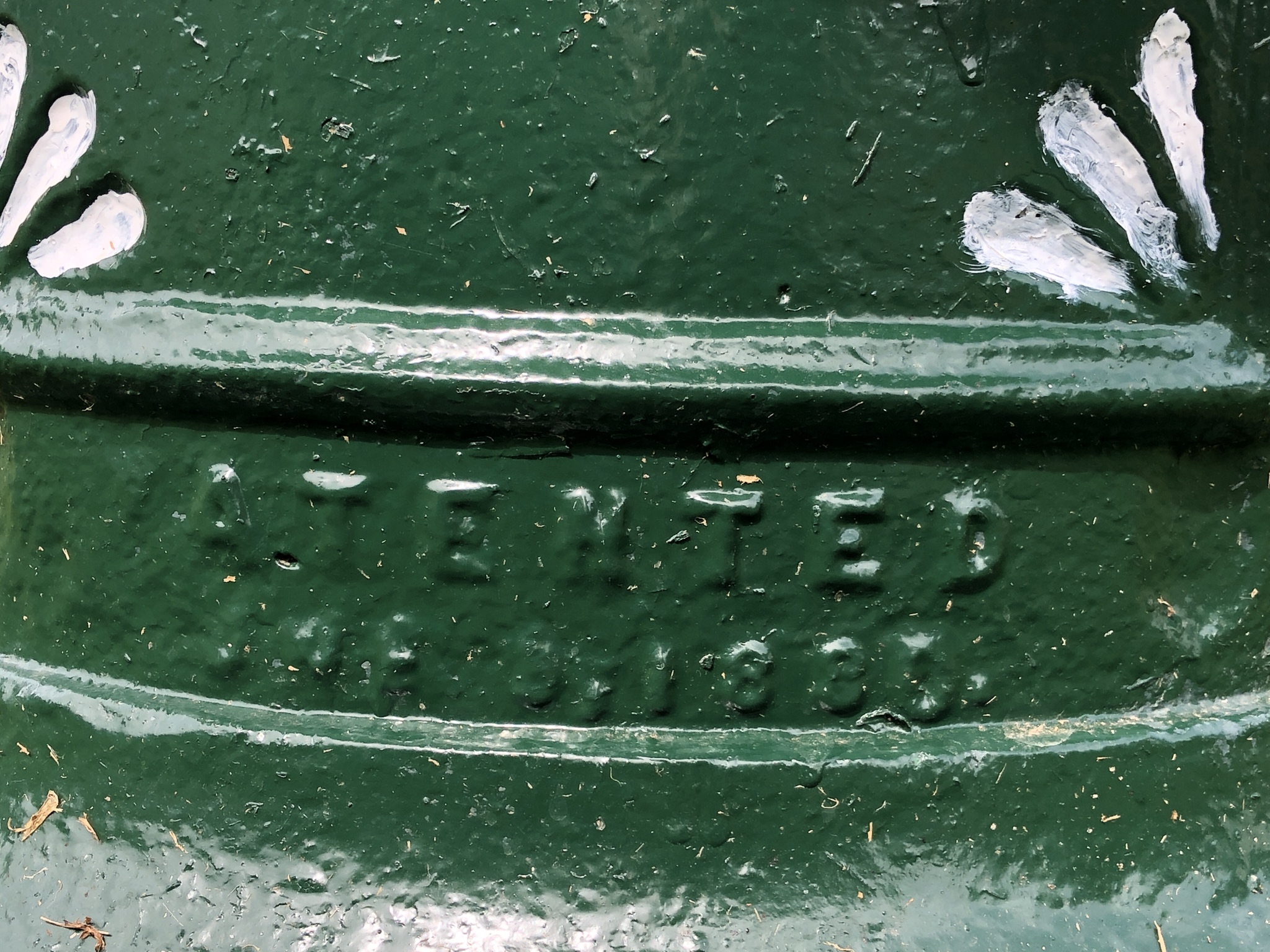 Close-up of pedestal of the fountain, declaring an illegible patent number.